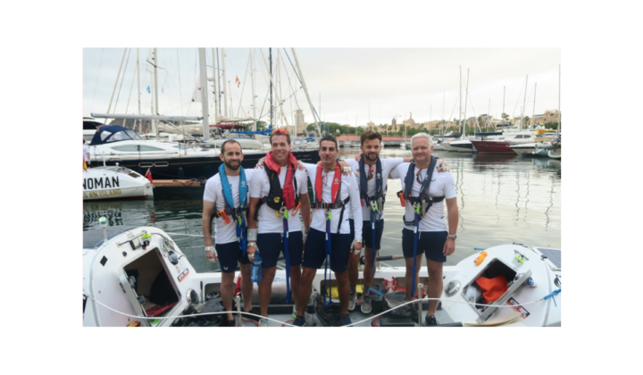 An image of the Amiqus team standing at the docks with boats wearing safety gear.