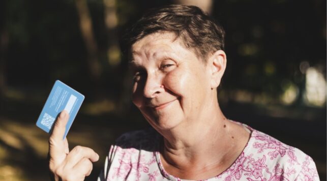 A woman holding a ProxyAddress card looking happy.