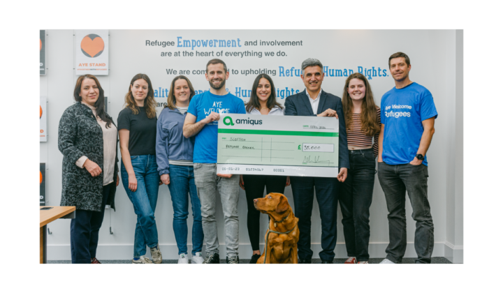 Amiqus CEO Callum Murray and team handing over a cheque of £35k to Dr Sabir Zazai, Chief Executive of the Scottish Refugee Council at their office in Glasgow