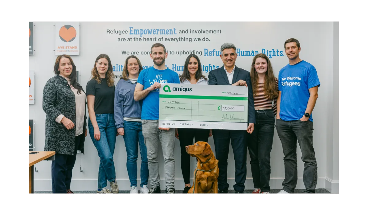 Amiqus CEO Callum Murray and team handing over a cheque of £35k to Dr Sabir Zazai, Chief Executive of the Scottish Refugee Council at their office in Glasgow